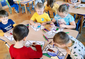 Dzieci wykonują pracę plastyczną - witraż pt. Znicz dla bohatera.